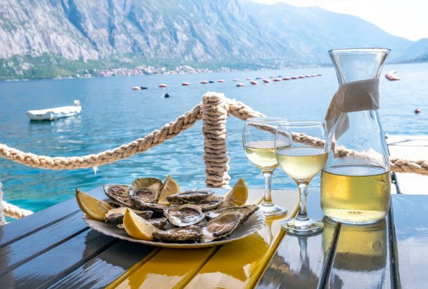 Oysters and white wine in a restaurant with a sea view.